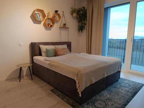 a bedroom with a bed and a large window at Cozy one-room apartment with garage and AC in Bratislava