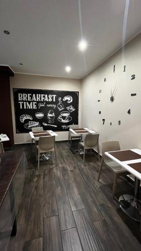 a dining room with tables and a clock on the wall at B&B Leus Appartment in Reggio Calabria