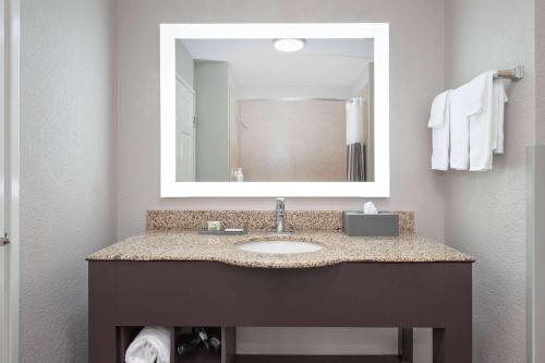 a bathroom with a sink and a mirror at La Quinta by Wyndham Alvarado in Alvarado