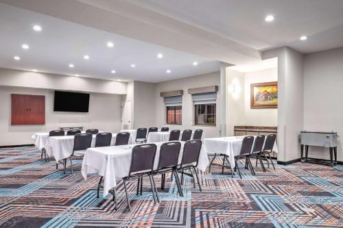 a conference room with white tables and chairs and a screen at La Quinta by Wyndham Alvarado in Alvarado