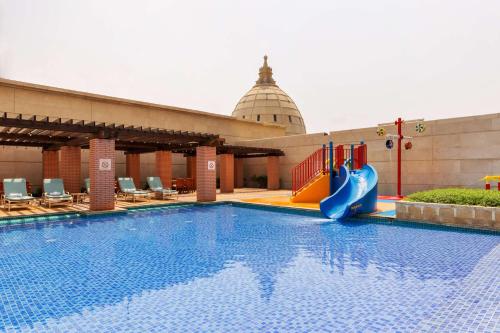 a swimming pool with a slide in a building at Hilton Dubai Al Habtoor City in Dubai