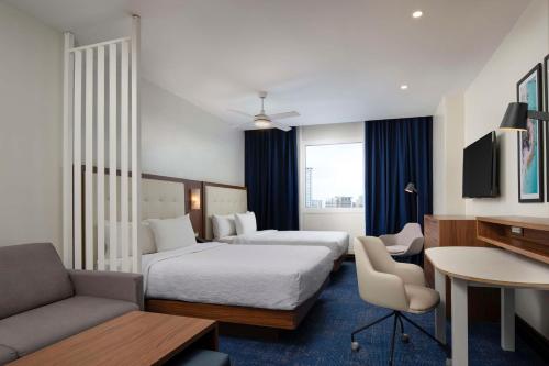 Кровать или кровати в номере Homewood Suites By Hilton Santo Domingo