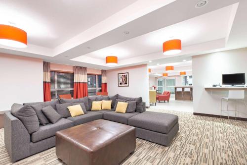 a living room with a gray couch and a table at Microtel Inn & Suites by Wyndham Fort McMurray in Fort McMurray