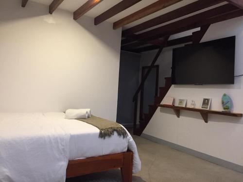 a bedroom with a bed and a flat screen tv at Amihan Bungalows in General Luna
