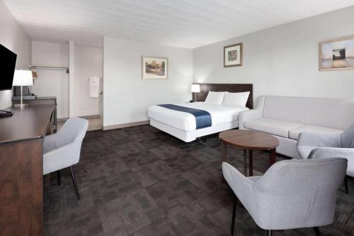 a hotel room with a bed and a couch at Travelodge by Wyndham Cochrane Ontario in Cochrane