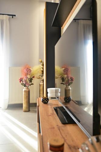 a bathroom with a mirror and a counter with flowers at Nychome in Ayía Marína