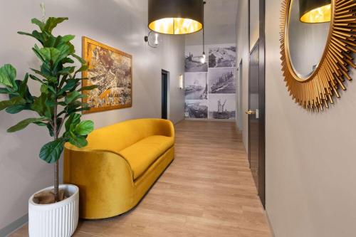 a yellow chair and a plant in a hallway at Riverbend Hotel and Suites, Trademark Collection by Wyndham in Ashtabula
