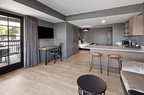 a kitchen and living room with a counter and chairs at Riverbend Hotel and Suites, Trademark Collection by Wyndham in Ashtabula