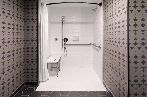 a bathroom with a shower with a bench in it at Riverbend Hotel and Suites, Trademark Collection by Wyndham in Ashtabula
