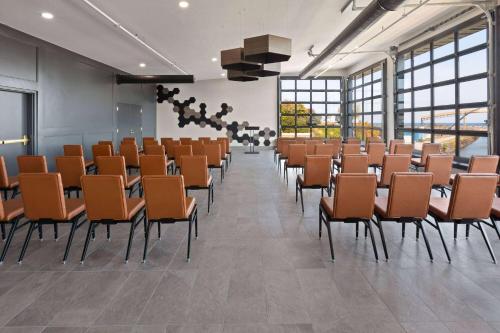 a large room with chairs and tables and windows at Riverbend Hotel and Suites, Trademark Collection by Wyndham in Ashtabula