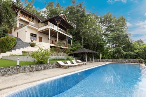 a villa with a swimming pool and a house at Villa Moon Talay View in Patong Beach