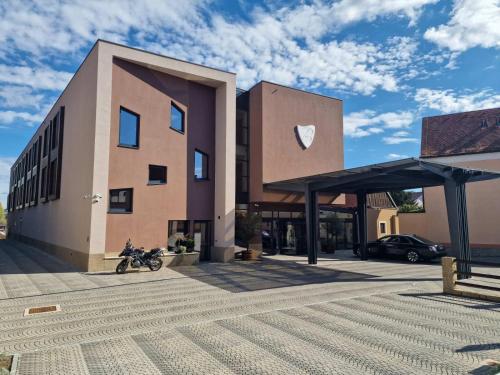 a building with a motorcycle parked in a parking lot at Hotel Bernarda in Varaždinske Toplice