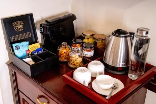 a counter with a coffee maker and a coffee pot on it at BrijRama Palace, Varanasi - By the Ganges in Varanasi