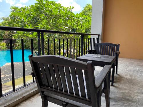 a table and chairs on a balcony with a view of the water at Chalicha Resort in Chumphon