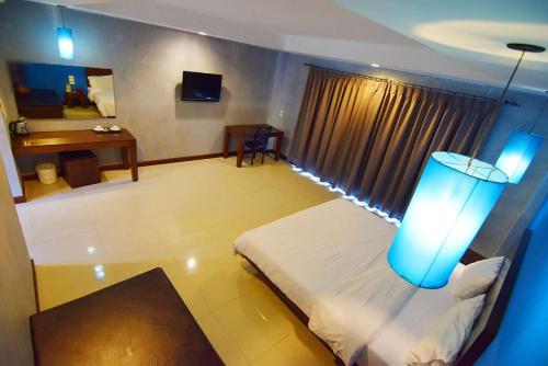 a room with a bed and a window with a blue light at Chalicha Resort in Chumphon