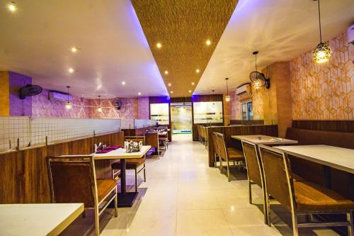 a dining room with tables and chairs in a restaurant at FabHotel Narsingi - Nr Global Eye Hospital, Narsingi in Hyderabad