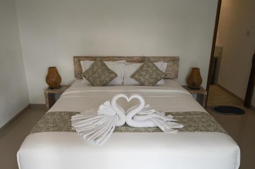 a bed with two white swans forming a heart at Maganda Villa in Tabanan