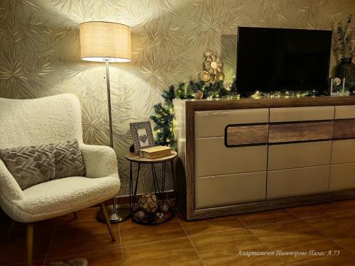 a living room with a tv and a chair and a christmas tree at Apartment Pamporovo Palaсe A75 in Pamporovo