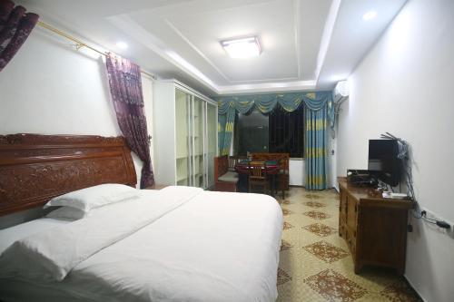 a bedroom with a bed and a television in it at LQJ Riverside Guest House in Fenghuang