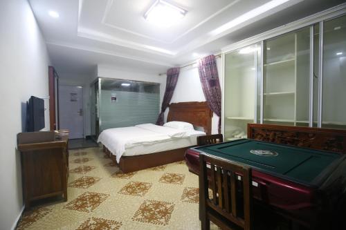 a bedroom with a bed and a pool table at LQJ Riverside Guest House in Fenghuang