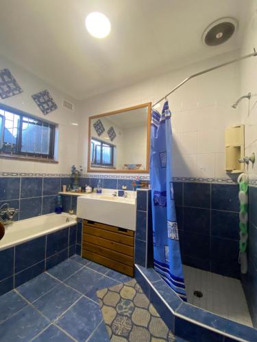 Un baño con bañera, lavabo y espejo. en Montclair Forest Guest House, en Durban
