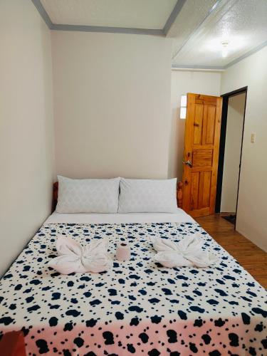 a bedroom with a bed with a black and white comforter at Bogah Lodge in Banaue