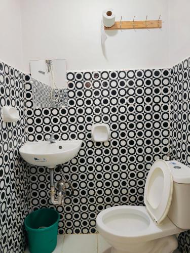 a bathroom with a white toilet and a sink at Bogah Lodge in Banaue