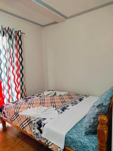 a bed in a room with ties on the wall at Bogah Lodge in Banaue