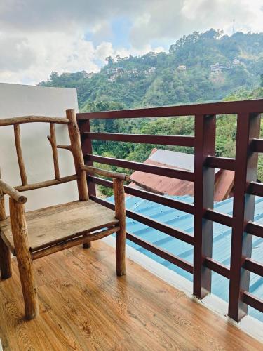 a wooden bench sitting on a balcony overlooking the water at Bogah Lodge in Banaue