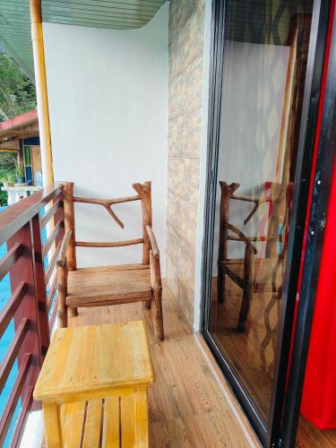 a wooden bench sitting on the porch of a house at Bogah Lodge in Banaue