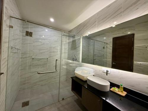 Un baño con ducha, lavabo y espejo. en Deluxe Twin Bed Apartment by Renttini, en Kamala Beach
