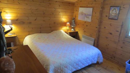 a bedroom with a bed in a wooden room at chalet 4 à 6 pers à la campagne 15 mn plages et Ajaccio grand terrain arboré calme assuré in Afa