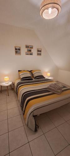 a bedroom with a bed with two lamps on it at Location, 10 mn des plages. in Saint-Coulomb