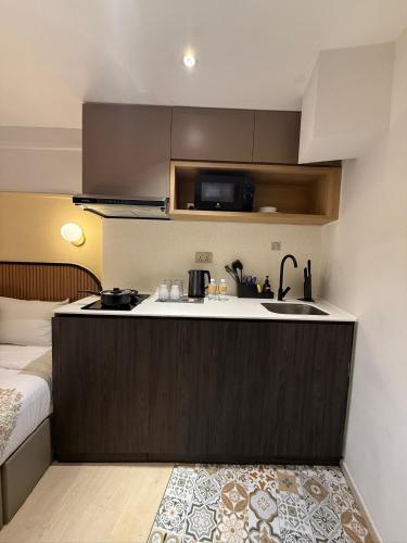 a small kitchen with a sink and a bed at ISA Hotel Amber Road in Singapore
