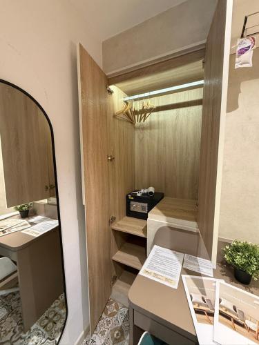 a room with a mirror and a desk and a sink at ISA Hotel Amber Road in Singapore