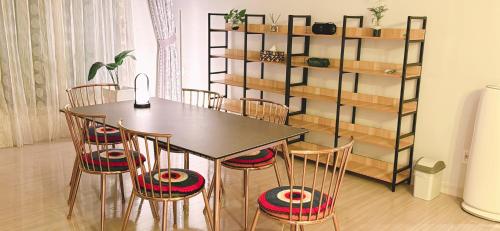 a dining room with a table and chairs and a shelf at st ar house in Goyang