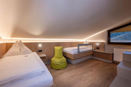 a small room with two beds and a window at Bliem's Familienhotel in Haus im Ennstal