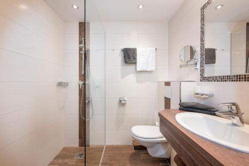 a bathroom with a toilet and a sink and a shower at Bliem's Familienhotel in Haus im Ennstal