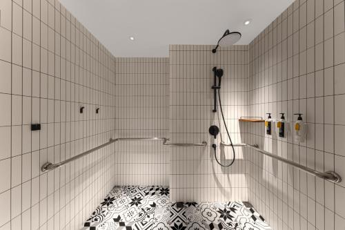 a bathroom with a shower with a black and white floor at Wanda Moments Hotel Beijing Dongba in Beijing