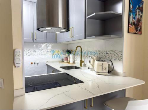 a kitchen with white cabinets and a sink at Estudio Zurycris in Torrox Costa