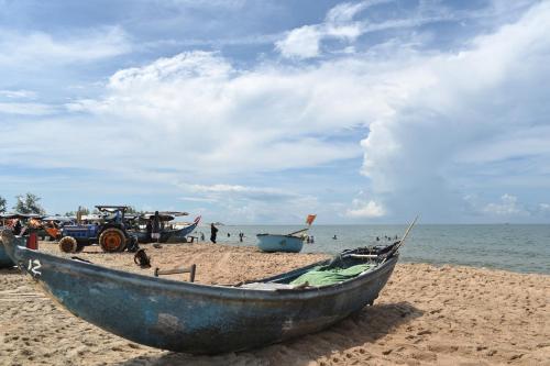 a boat sitting on a sandy beach near the ocean at Lucky Star Ho Tram Hotel & Restaurant in Ho Tram