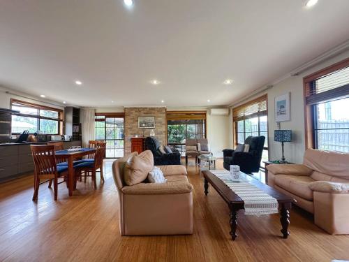 a living room with a couch and a table at Seven Mile Beach House - 5 minutes to the Airport in Seven Mile Beach
