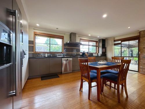 a kitchen with a table and chairs in a room at Seven Mile Beach House - 5 minutes to the Airport in Seven Mile Beach