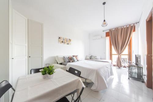 a white living room with two tables and a couch at Locami Apartment Niguarda in Milan