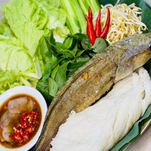 a plate of food with a fish and a salad at Thisak Resort Cheung phnom kulen in Siem Reap