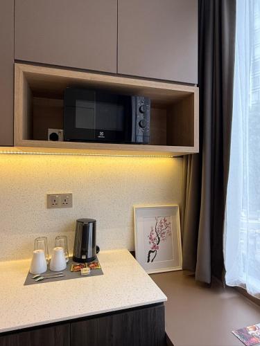 a kitchen counter with a coffee maker and a microwave at ISA Hotel Amber Road in Singapore