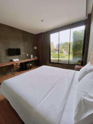 ein Schlafzimmer mit einem großen Bett und einem großen Fenster in der Unterkunft boomresort in Ron Phibun