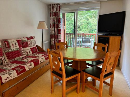 un salon avec une table et un canapé dans l'établissement St Lary Village T2 4p lumineux - piscine - balcon - parking, à Saint-Lary-Soulan