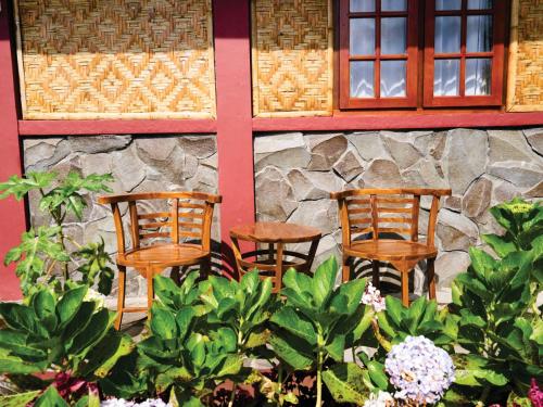 a group of chairs sitting in front of a building at Taman Syailendra Cottage Dieng in Dieng