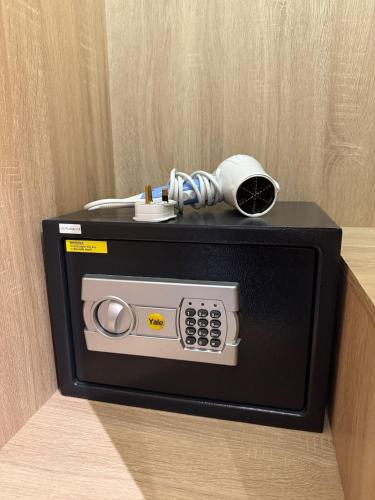 a microwave with a phone on top of it at ISA Hotel Amber Road in Singapore
